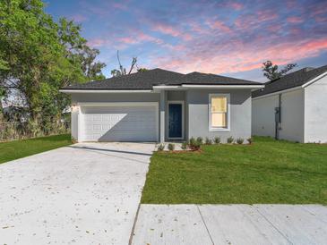 Charming single-Gathering home featuring a well-manicured lawn and an attached one-car garage at 1449 Monte Carlo Trl, Orlando, FL 32805