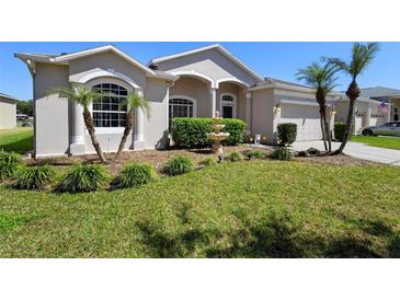 Charming home featuring manicured lawn, mature palms, and a decorative fountain at 213 Strathmore Cir, Kissimmee, FL 34744