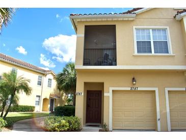 Inviting two-story home features a private screened balcony and an attached one car garage at 2787 Oakwater Dr, Kissimmee, FL 34747