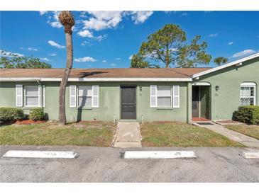 Charming exterior view of this condo featuring a well-kept lawn, white shutters, and neutral paint at 31 Las Palmas Way, Kissimmee, FL 34743