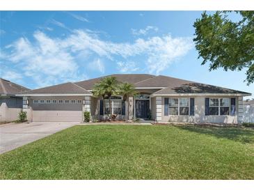 Charming one-story home featuring a well-manicured lawn and a two car garage at 3263 Lorimar Ln, St Cloud, FL 34772