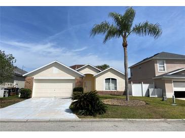 Charming single Gathering home with a two-car garage and a well-manicured lawn and a tall palm tree at 366 Jaybee Ave, Davenport, FL 33897