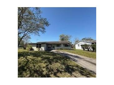 Charming single-story home with a classic design and a spacious front yard and a long driveway leading to the street at 4226 Lake Richmond Dr, Orlando, FL 32811