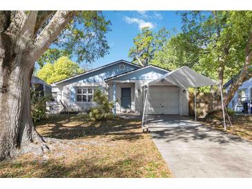 Charming single-story home with white brick, carport, manicured landscaping, and mature trees at 612 California Ave, St Cloud, FL 34769