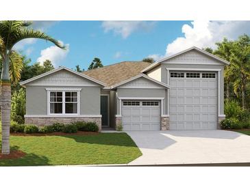 Charming single-Gathering home featuring a three-car garage and meticulously landscaped front yard at 1011 Wisteria Way, Dundee, FL 33838