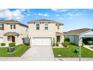 Charming two-story home with manicured lawn, a two car garage, and inviting curb appeal at 2879 Common Crane Ct, Harmony, FL 34773