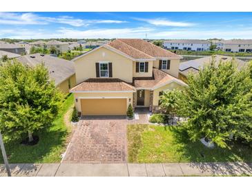 Charming two-story home with a brick driveway, attached garage, and well-manicured front lawn at 624 Sardinia Circle, Davenport, FL 33837