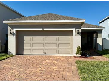 Charming single-Gathering home featuring a two-car garage and a brick-paved driveway at 813 Marcel Loop, Davenport, FL 33837