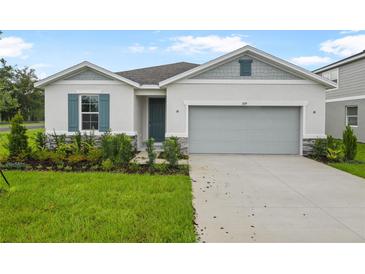 Charming single-Gathering home with a manicured lawn and a two-car garage at 1039 Wisteria Way, Dundee, FL 33838
