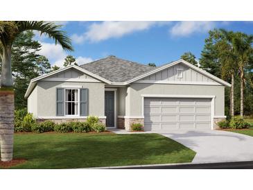 Charming single-story home with a two-car garage, well-manicured lawn, and inviting neutral-toned facade at 1106 Olivine Ave, Dundee, FL 33838