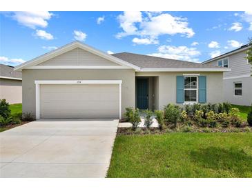 Charming single-story home with a two-car garage, landscaped yard, and lovely blue shutter at 1114 Olivine Ave, Dundee, FL 33838