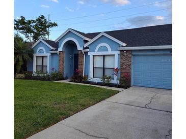 Charming single-story home featuring a well-manicured lawn and a two-car garage at 12966 Broakfield Cir, Orlando, FL 32837