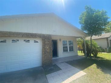 Charming single-story home featuring a two-car garage, stone accents, and a well-maintained front yard at 1304 Mill Creek Pl, Kissimmee, FL 34744