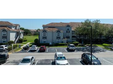 Beautiful two-story condo building featuring ample parking, well-maintained landscaping, and neutral stucco siding at 14049 Fairway Island Dr # 122, Orlando, FL 32837