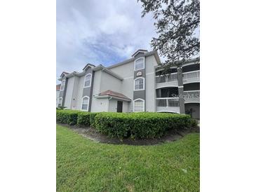Well maintained condo building with lush landscaping and a view from the front yard at 14049 Fairway Island Dr # 127, Orlando, FL 32837