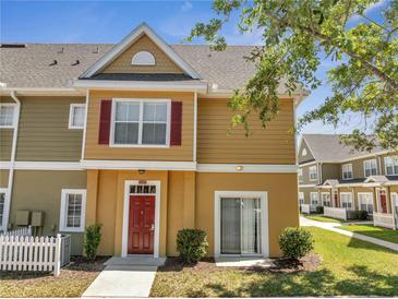 Inviting townhouse with red door, red shutters, sidewalk, and well-maintained landscaping at 4561 Yellowgold E Rd # 107, Kissimmee, FL 34746