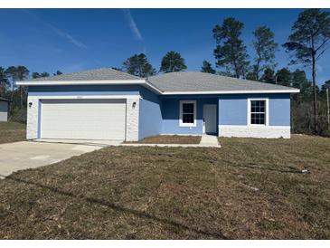 Charming single-story home featuring a blue exterior, white accents, a gray roof, and an attached garage at 4863 Sw 159Th Ln Rd, Ocala, FL 34473