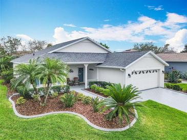 Beautiful one-story home with a well-manicured lawn, mature trees, and a two-car garage at 501 Heartwell Dr, Poinciana, FL 34759