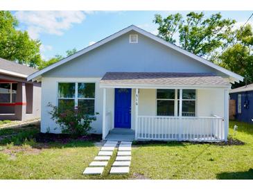 Charming single-story home with a blue front door, white picket fence, and well-maintained lawn at 516 W 7Th St, Lakeland, FL 33805