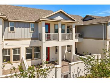 Charming townhome featuring a covered porch, balcony, and well-maintained landscaping at 7063 Nemours Pkwy, Orlando, FL 32827