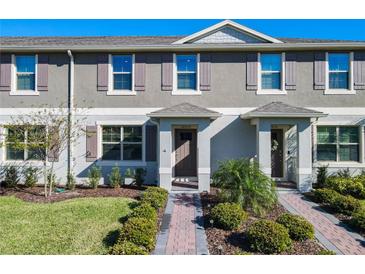 Charming townhome featuring a well-maintained front lawn and inviting entryway at 12035 Holystone St, Winter Garden, FL 34787
