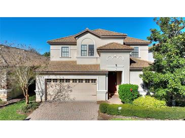 Charming two-story home with a tile roof, brick driveway and two-car garage at 1454 Myrtlewood St, Davenport, FL 33896