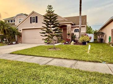 Charming single-Gathering home featuring a well-maintained lawn, landscaped garden and two-car garage at 14945 Huntcliff Park Way, Orlando, FL 32824