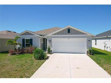 Charming single-Gathering home featuring a two-car garage, well-maintained lawn, and inviting curb appeal at 219 Summerlin Loop, Haines City, FL 33844