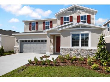 Inviting two-story home with a two-car garage, stone accents, and red shutters at 2961 Gavin Sky Dr, Kissimmee, FL 34744