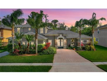 Beautiful single-Gathering home with a well-manicured lawn, mature landscaping, and a brick driveway at 3245 Heirloom Rose Pl, Oviedo, FL 32766