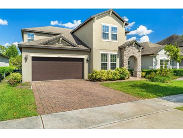 Charming two-story home featuring a brick driveway, attached two-car garage and a stone-accented entryway at 3447 Feathergrass Ct, Harmony, FL 34773