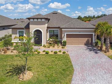 Charming single-story home featuring a manicured lawn and a brick-paved driveway leading to a two-car garage at 3775 Via Mazzini Ct, Kissimmee, FL 34759