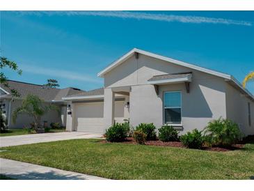 Charming single-story home with a well-manicured lawn and a two-car garage in a residential neighborhood at 5140 Four Strand Ct, St Cloud, FL 34772