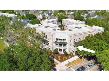 Attractive building exterior features manicured landscaping, decorative balconies and street parking at 675 Celebration Ave, Celebration, FL 34747