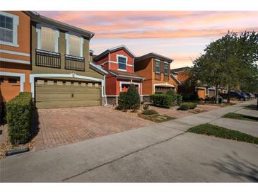 Colorful townhomes featuring brick driveways and well-maintained landscaping at 9535 Silver Buttonwood St, Orlando, FL 32832