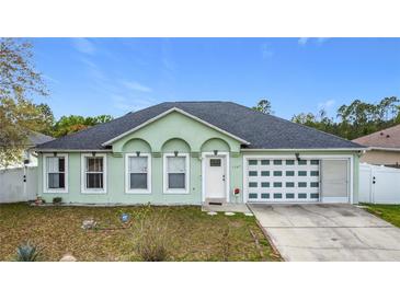 Charming single-story home featuring a unique garage door and manicured front lawn at 1167 Saint Tropez Ct, Kissimmee, FL 34759
