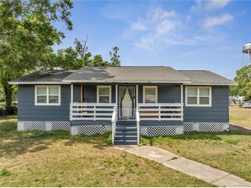 Charming single-story home featuring a lovely front porch with white railings and a well-maintained lawn at 1226 Pine St, Orlando, FL 32824