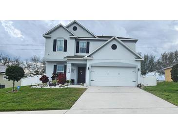 Charming two-story home with landscaped front yard and two-car garage at 2015 Barstow Ln, Dundee, FL 33838