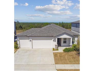 Inviting home featuring a three-car garage, covered porch, and manicured landscaping at 2238 Gold Dust Dr, Clermont, FL 34715