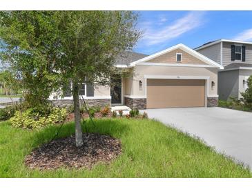 Inviting single-story home boasts a well-manicured lawn and a neutral color palette at 306 Alexandrite St, Deland, FL 32720