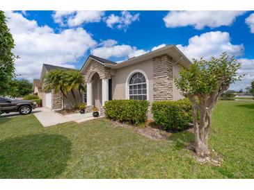 Charming home featuring a stone accent facade, well-manicured lawn, and lush landscaping at 4910 Culdesac Ct St, St Cloud, FL 34772