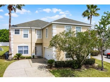 Charming two-story home with a well-manicured lawn and beautiful landscaping at 814 Bloomingdale Dr, Davenport, FL 33897