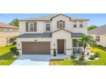 Charming two-story home featuring a well-manicured lawn, two-car garage and a welcoming front porch at 178 Forest View Dr, Davenport, FL 33896