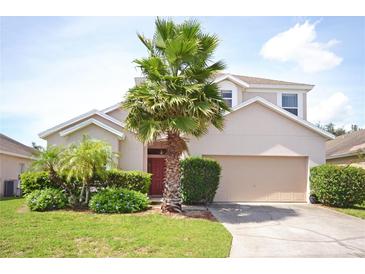 Charming single-Gathering home featuring a well-manicured lawn and mature palm trees in a residential neighborhood at 423 Corvina Dr, Davenport, FL 33897