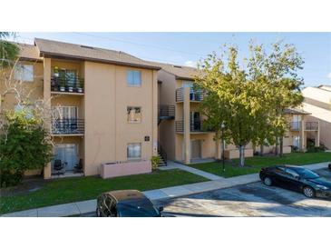 Charming condo building with neutral tones, balconies, well-maintained landscaping, and ample parking at 5226 Via Hacienda Cir # A314, Orlando, FL 32839