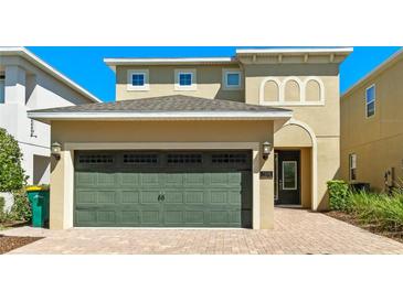 Inviting home featuring a two-car garage and brick driveway leading to a welcoming front entrance at 7556 Marker Ave, Kissimmee, FL 34747