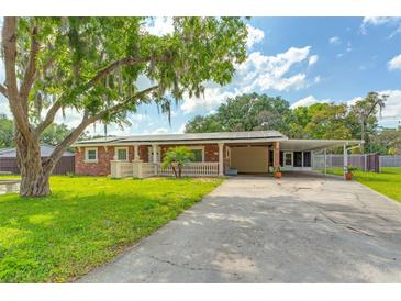 Charming single-story brick home featuring a covered front porch and spacious driveway at 1204 Pleasant Pl, Lakeland, FL 33801
