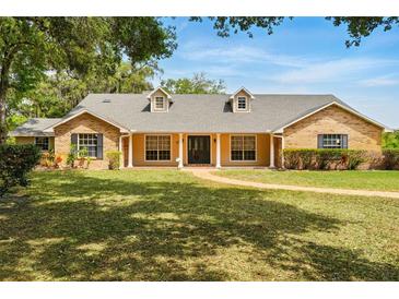 Charming single-story home boasts a manicured lawn and traditional brick and siding exterior at 3075 Simpson Rd, Kissimmee, FL 34744
