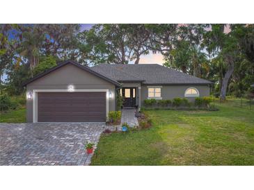 Charming single-story home with a brick driveway, two-car garage, and well-manicured lawn and landscaping at 420 Ketch Rd, St Cloud, FL 34771