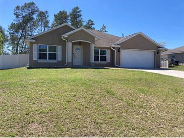 Charming single-story home with well-manicured lawn, attached garage, and inviting front entrance at 4490 Sw 169Th Pl, Ocala, FL 34473